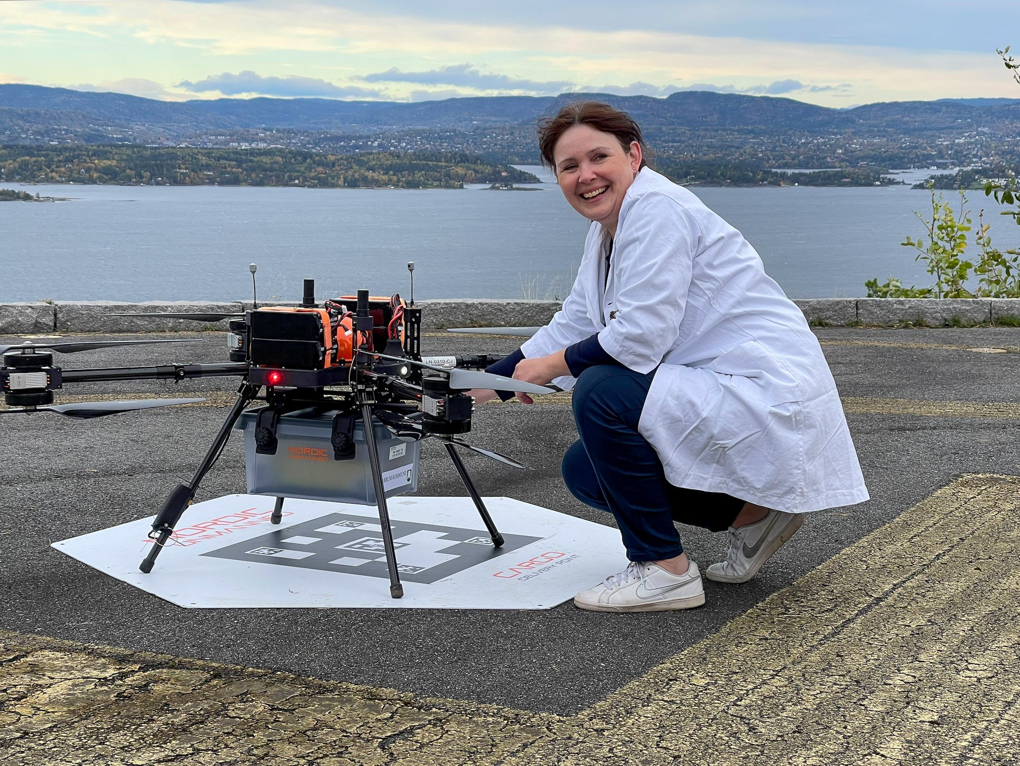 En person som sitter på en matte ved siden av en maskin