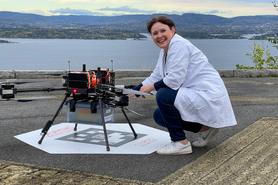 En person som sitter på en matte ved siden av en maskin