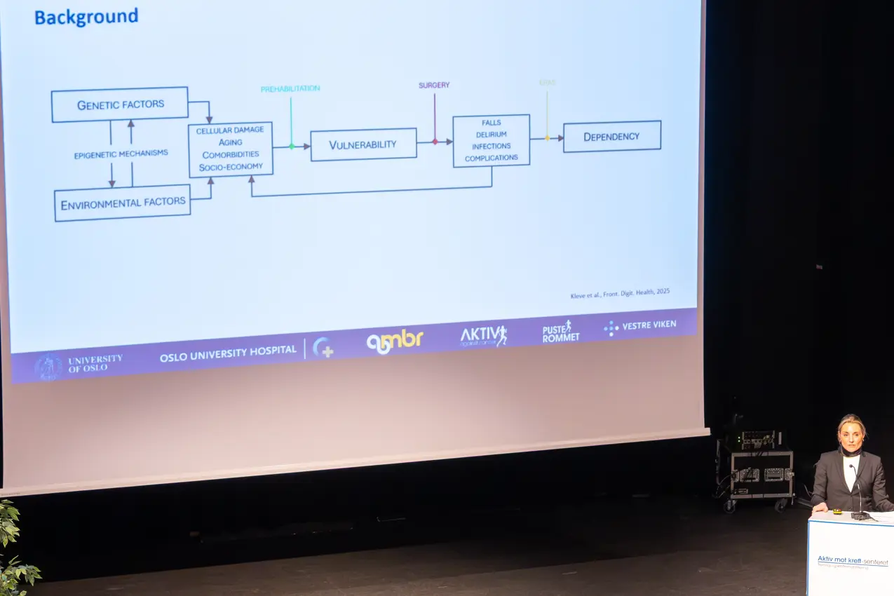 En mann som står foran en stor skjerm