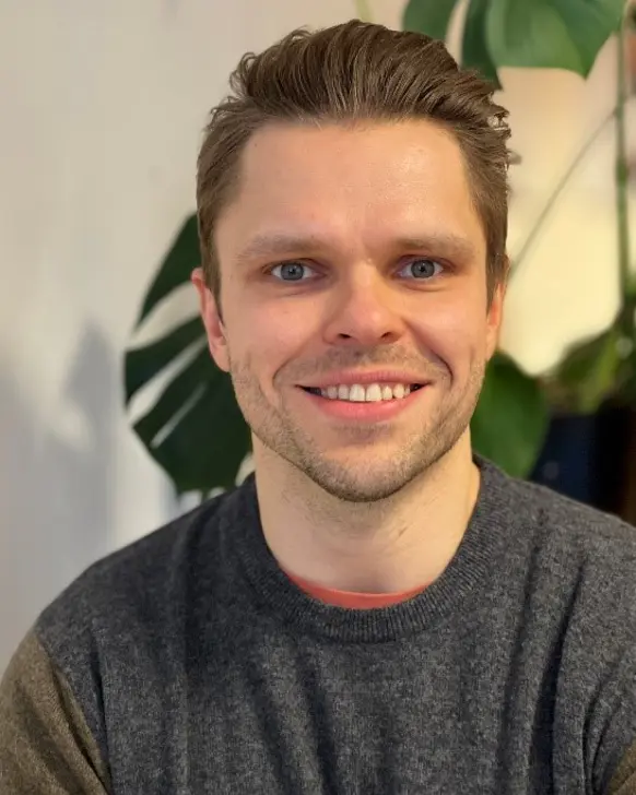 En mann som smiler til kameraet