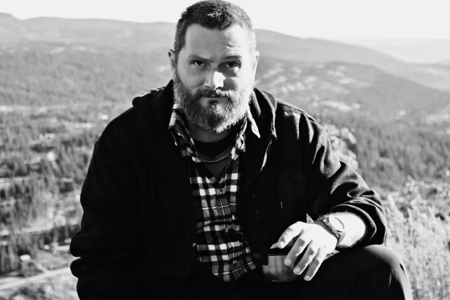 En mann som sitter på en høyde