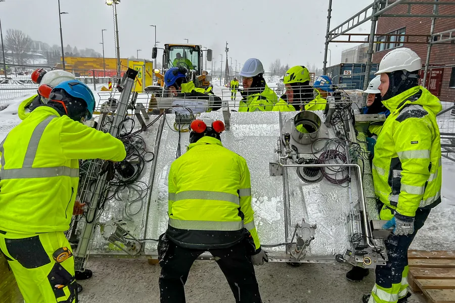 En gruppe mennesker i gule jakker som jobber med et byggeprosjekt
