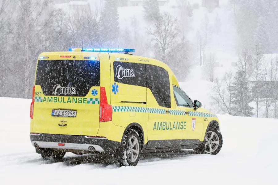 En gul og blå varebil i snøen