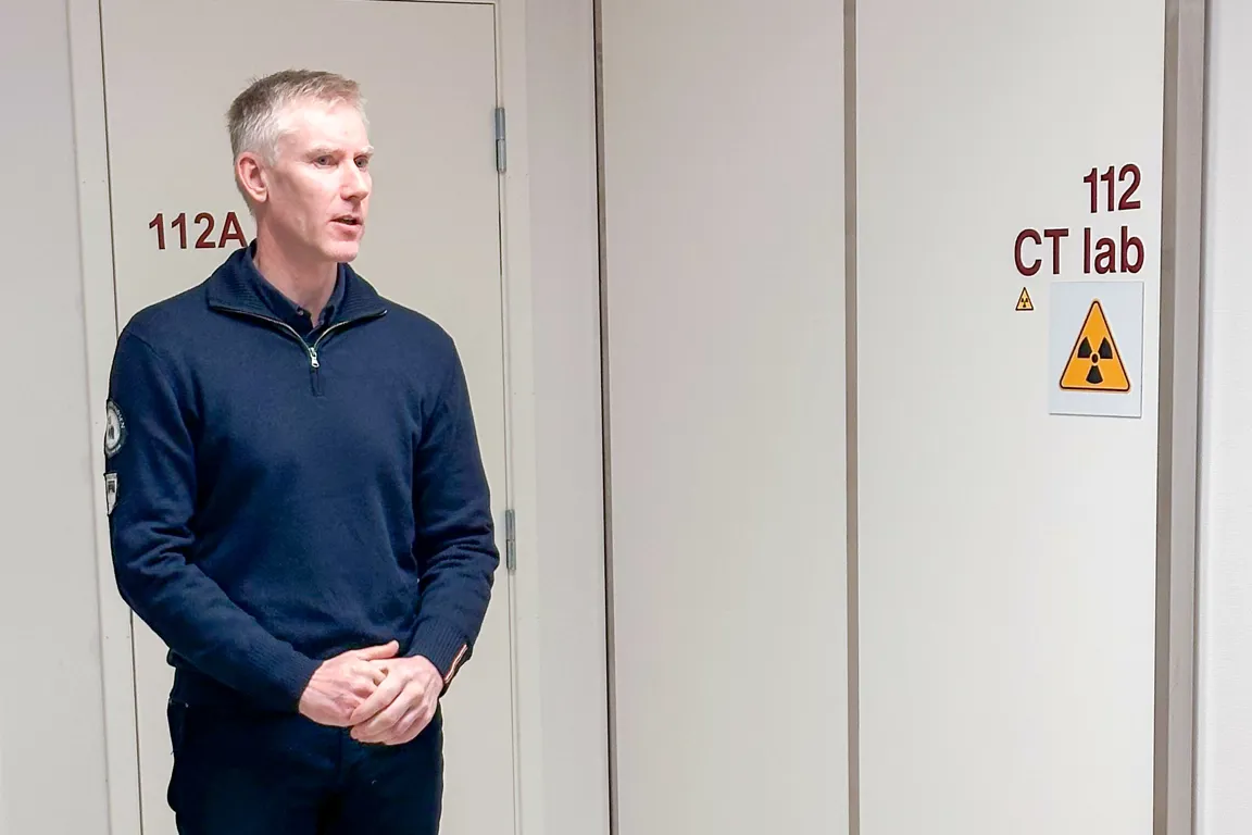 En mann som står foran en hvit dør