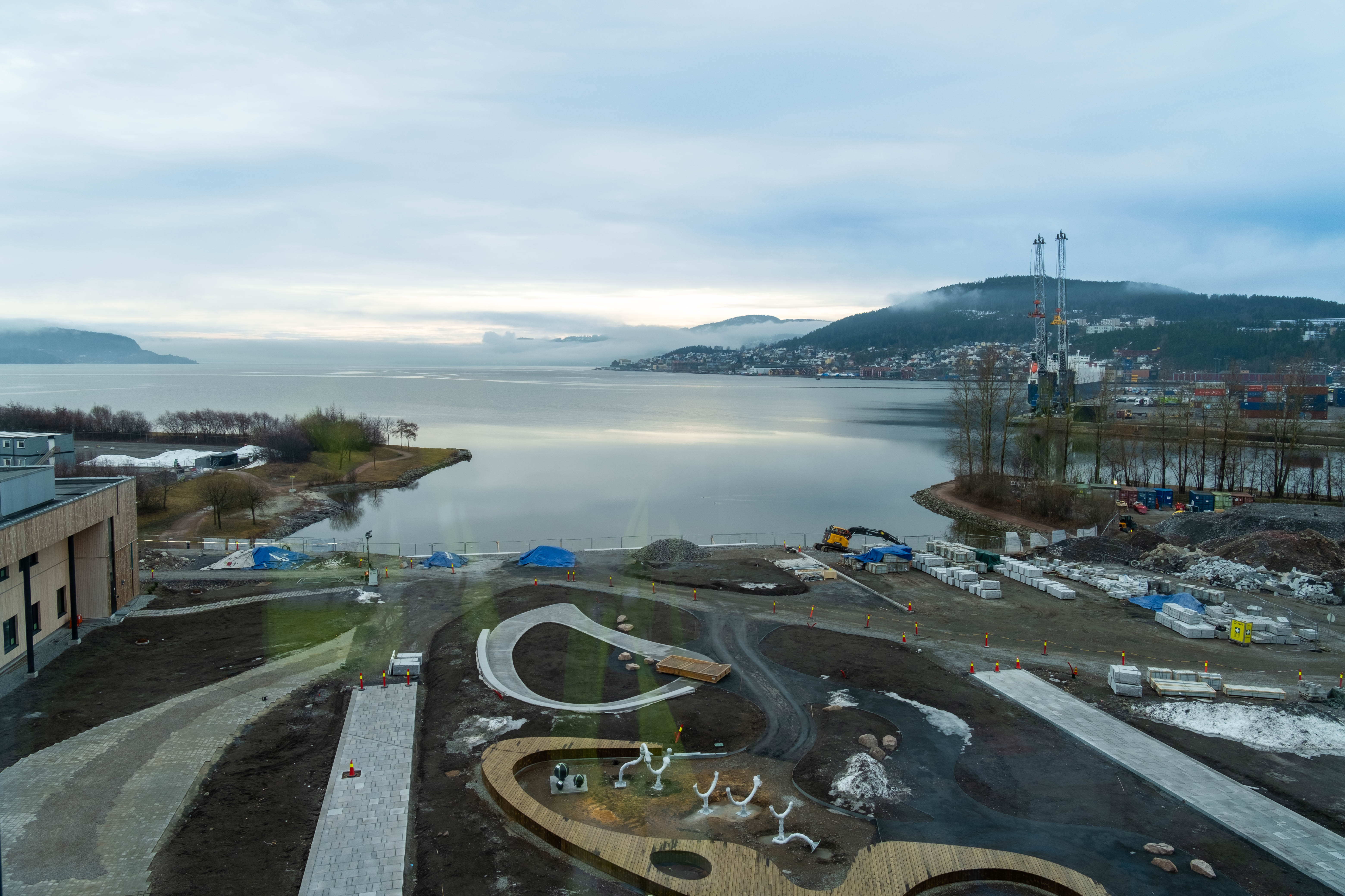 En vei ved siden av en vannmasse med snø på siden