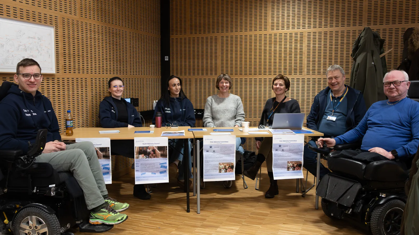 En gruppe mennesker som sitter ved et bord med bærbare datamaskiner