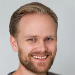 A man with a beard smiling