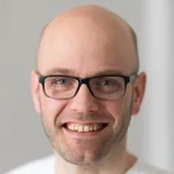A bald man wearing glasses