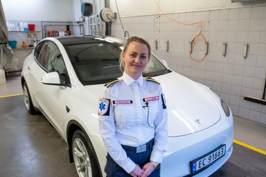 En person som står ved siden av en hvit bil