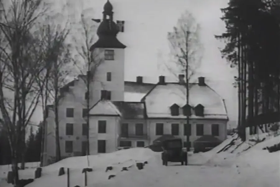 En bygning med tårn og trær foran