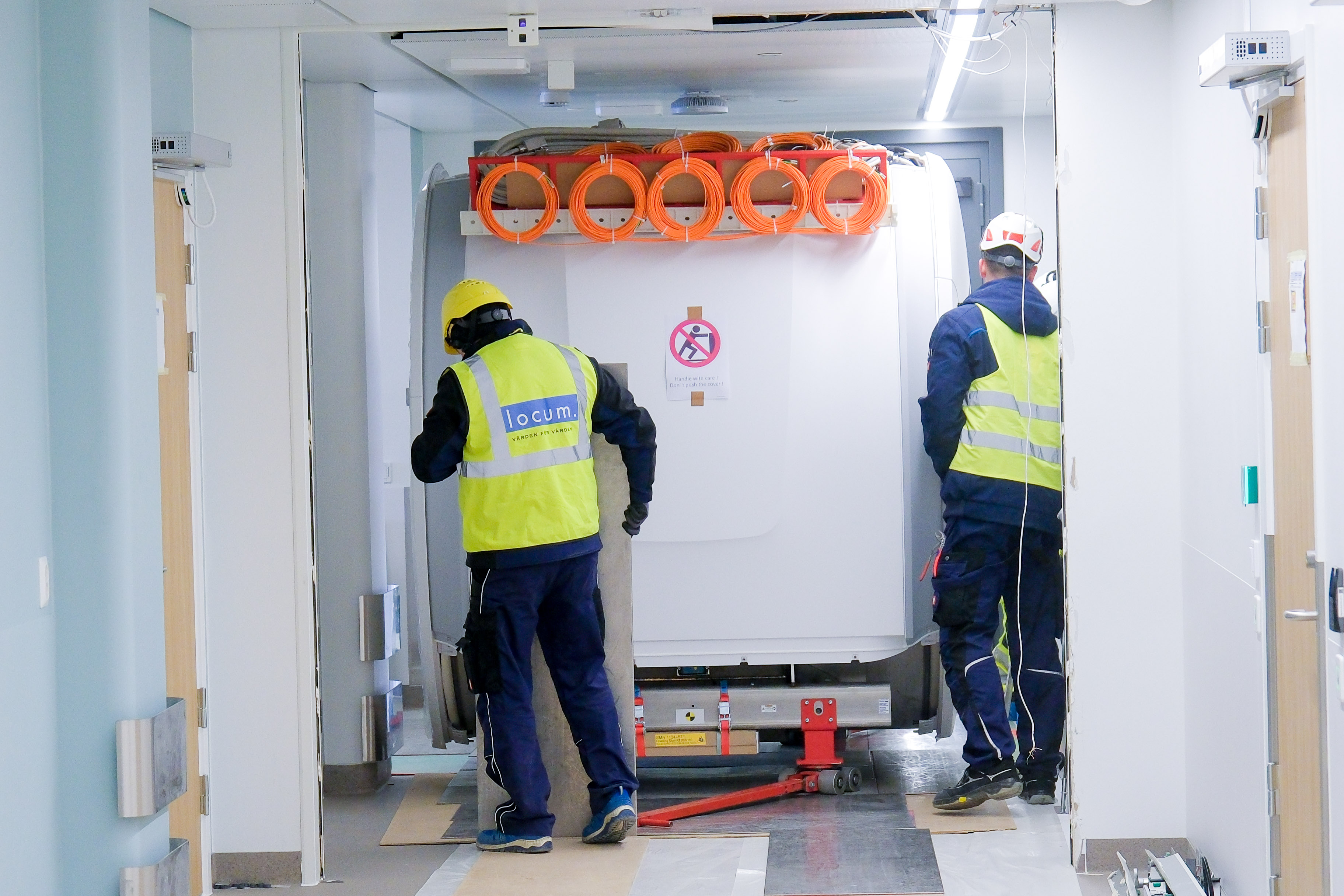 Noen få menn i gule jakker som står ved siden av en hvit lastebil