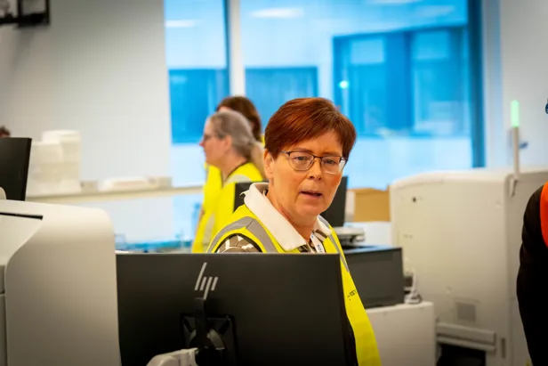 En mann som sitter ved et skrivebord med en bærbar datamaskin