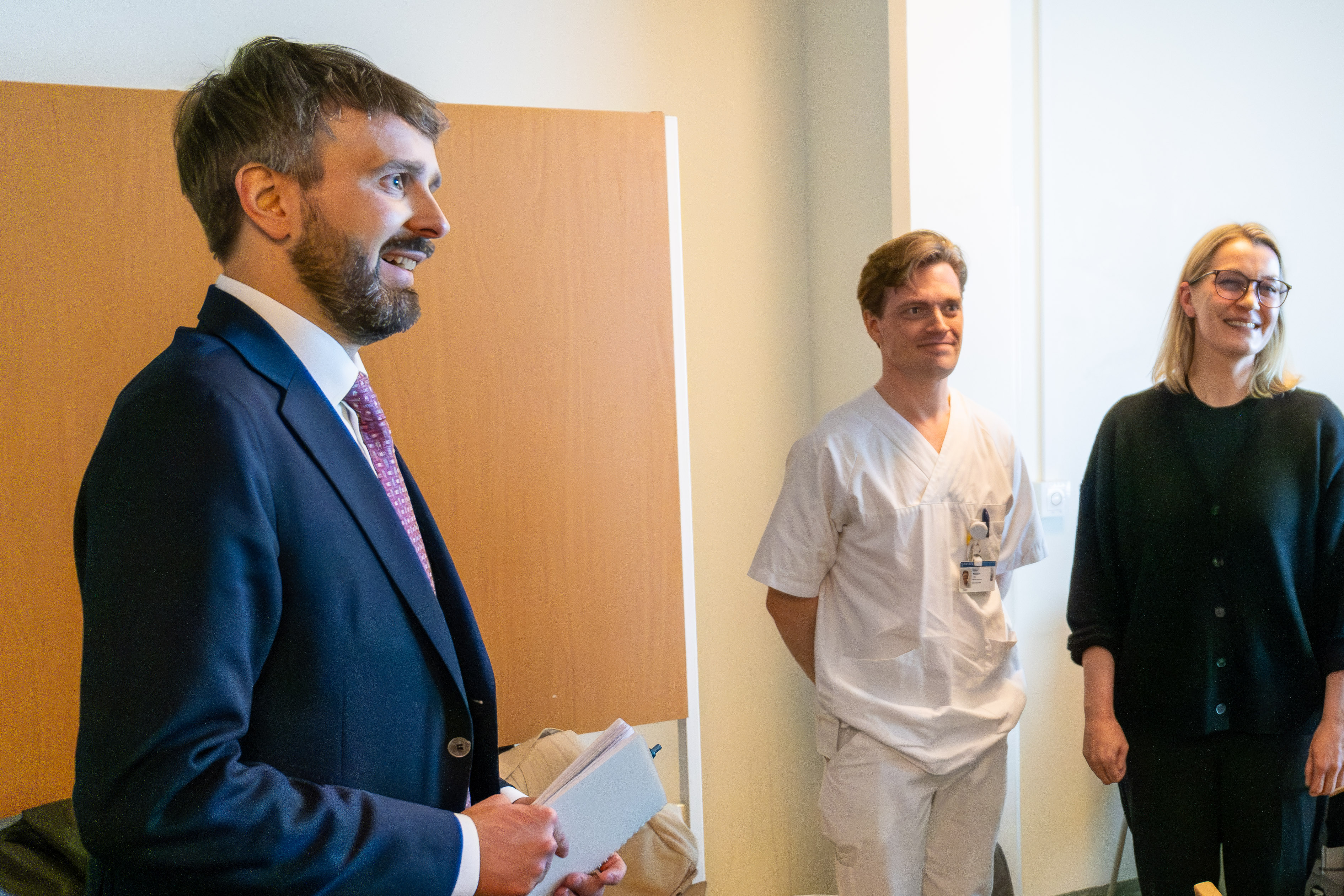 En person i dress som snakker med en gruppe mennesker