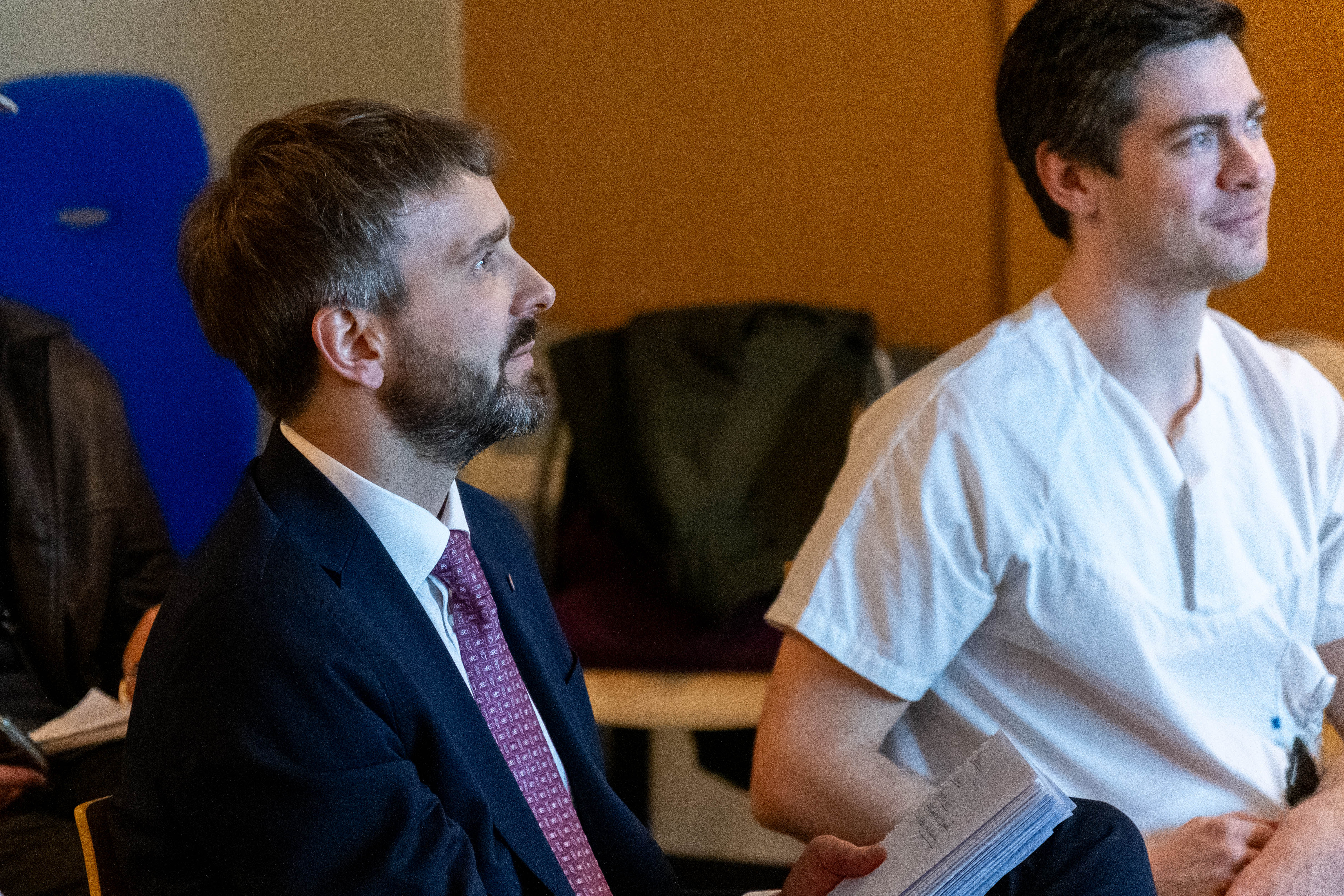 En mann i dress som snakker med en annen mann i dress