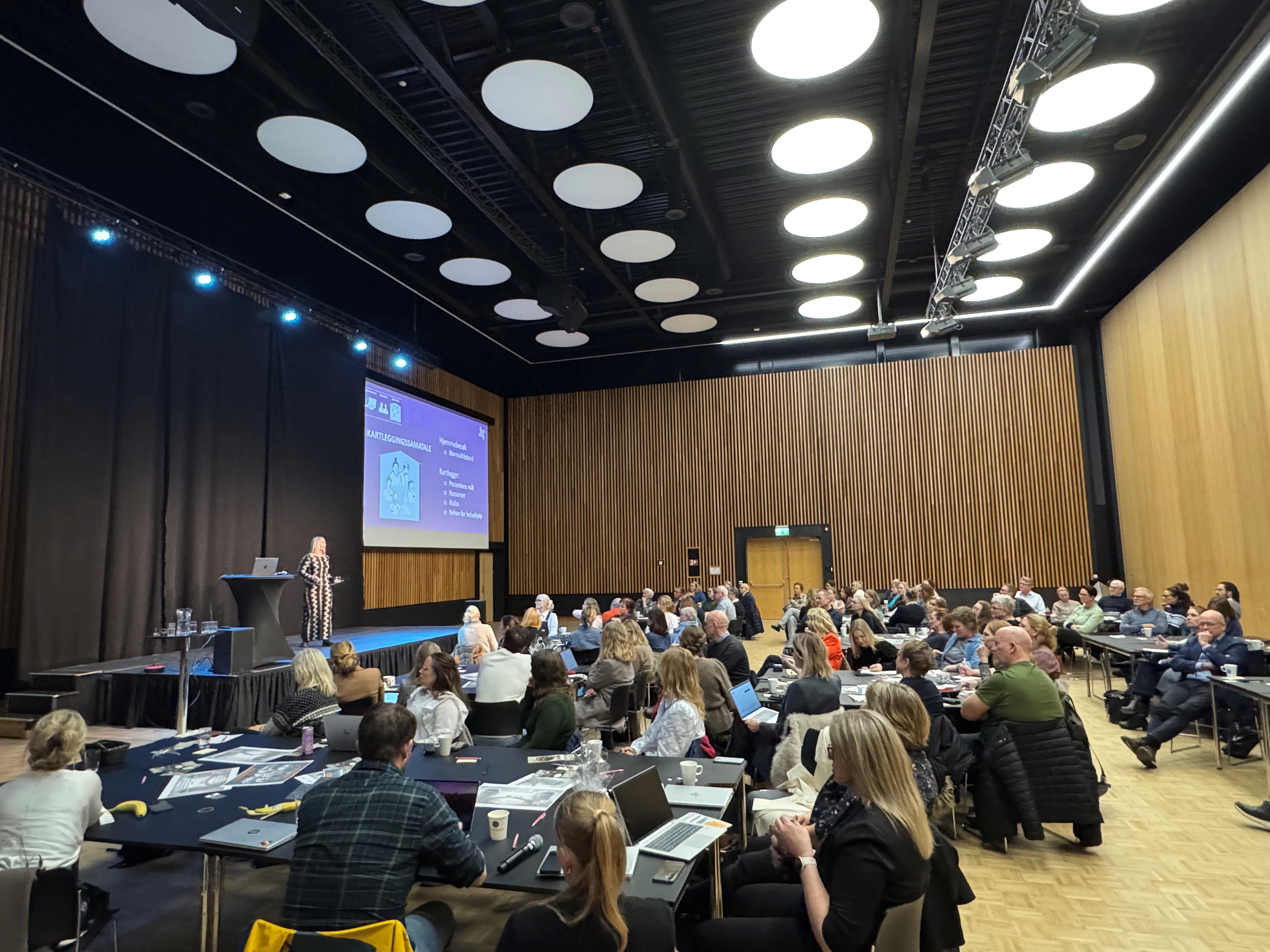 En gruppe mennesker som sitter i et konferanserom