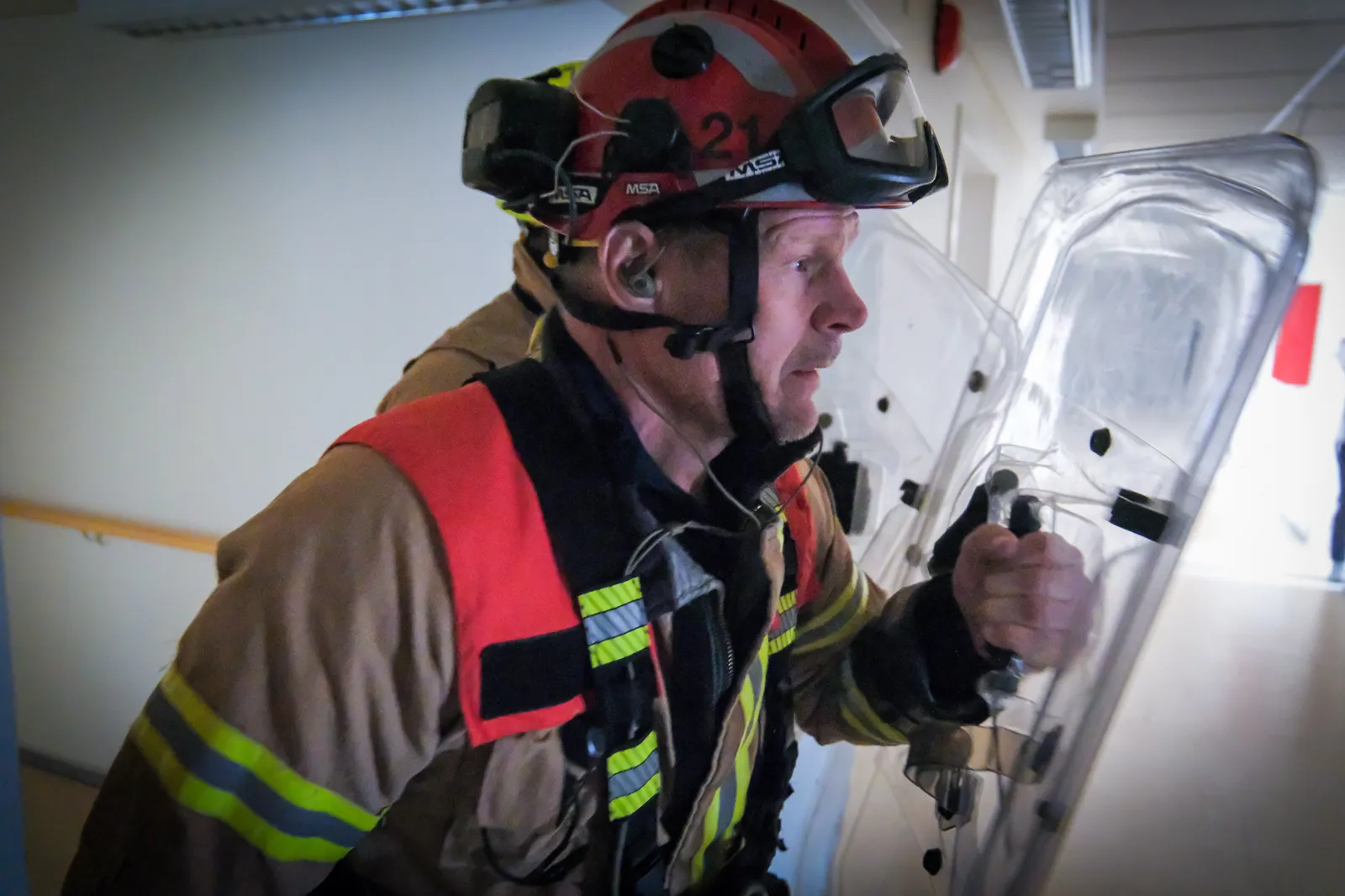 En brannmann som ser på et hvitt kjøleskap