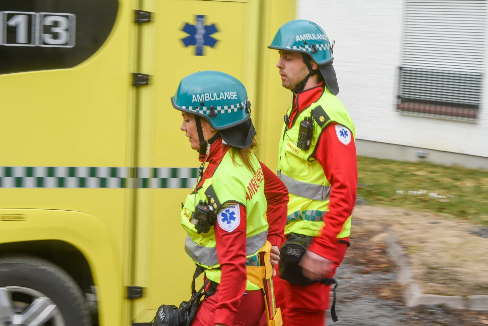 Et par brannmenn foran en gul brannbil