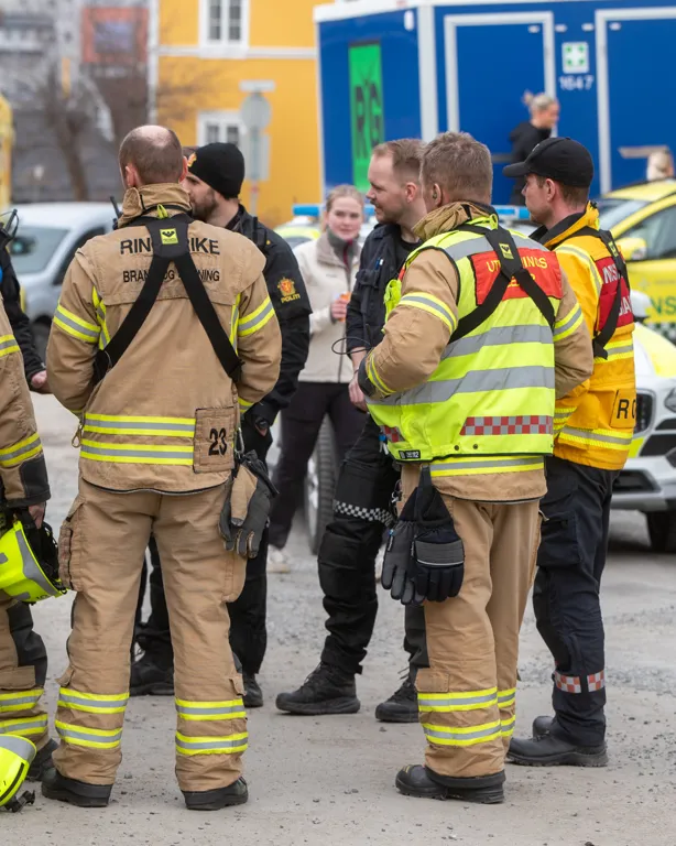 En gruppe mennesker står foran en brannbil