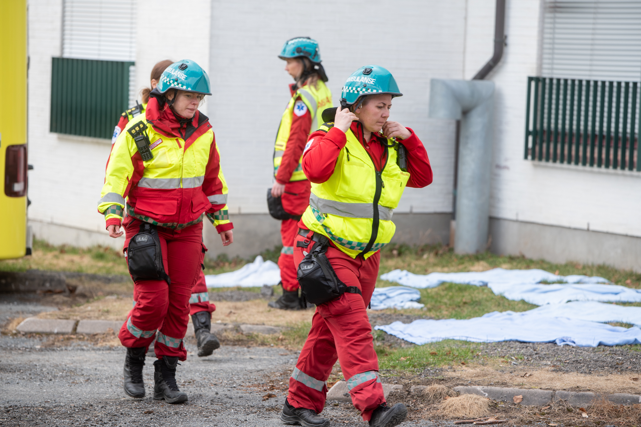 En gruppe mennesker med hjelmer som står på en gate