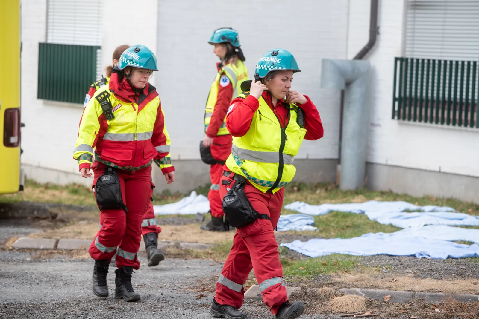 En gruppe mennesker med hjelmer som står på en gate