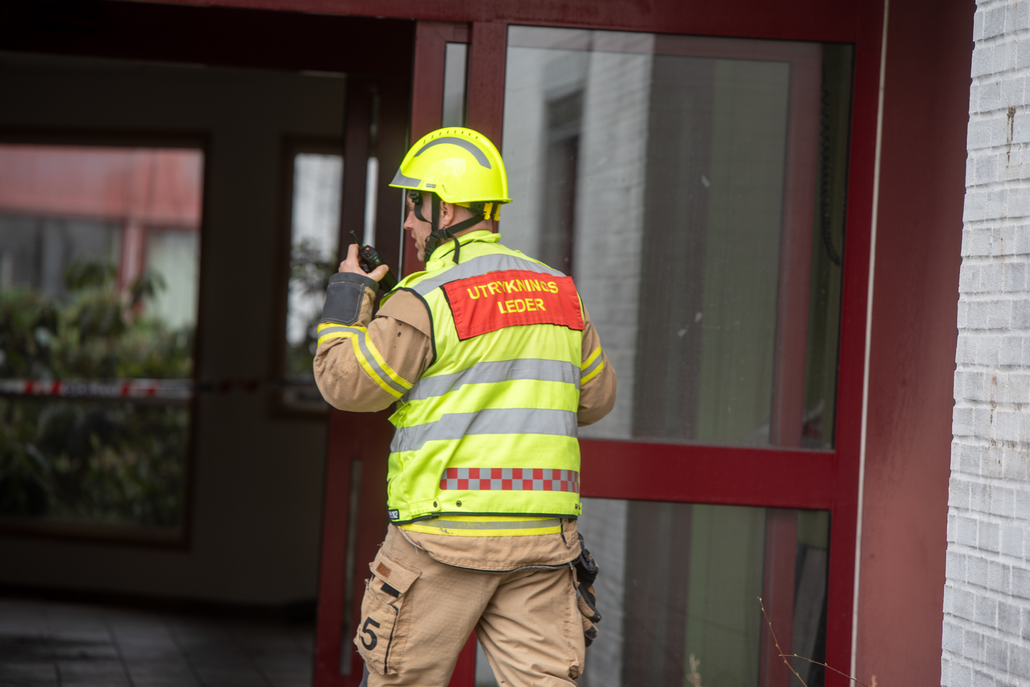 En person som bruker sikkerhetsvest og holder en drill