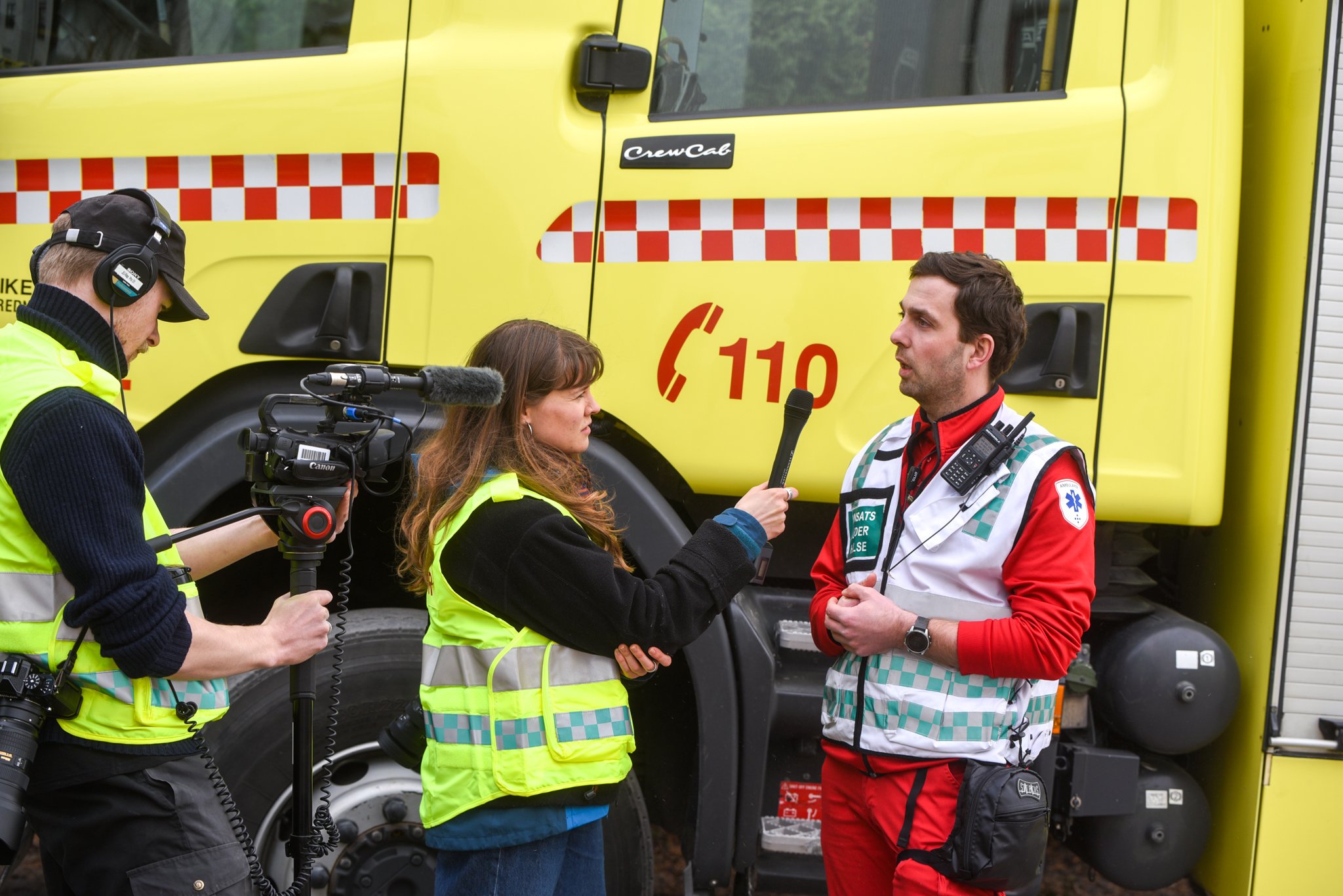 En gruppe mennesker som står ved siden av en brannbil