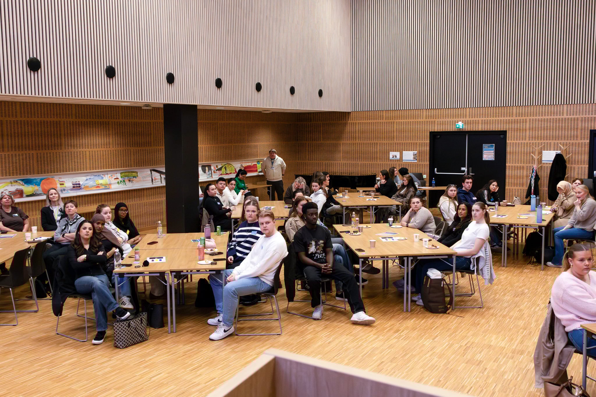 En gruppe mennesker som sitter i et rom