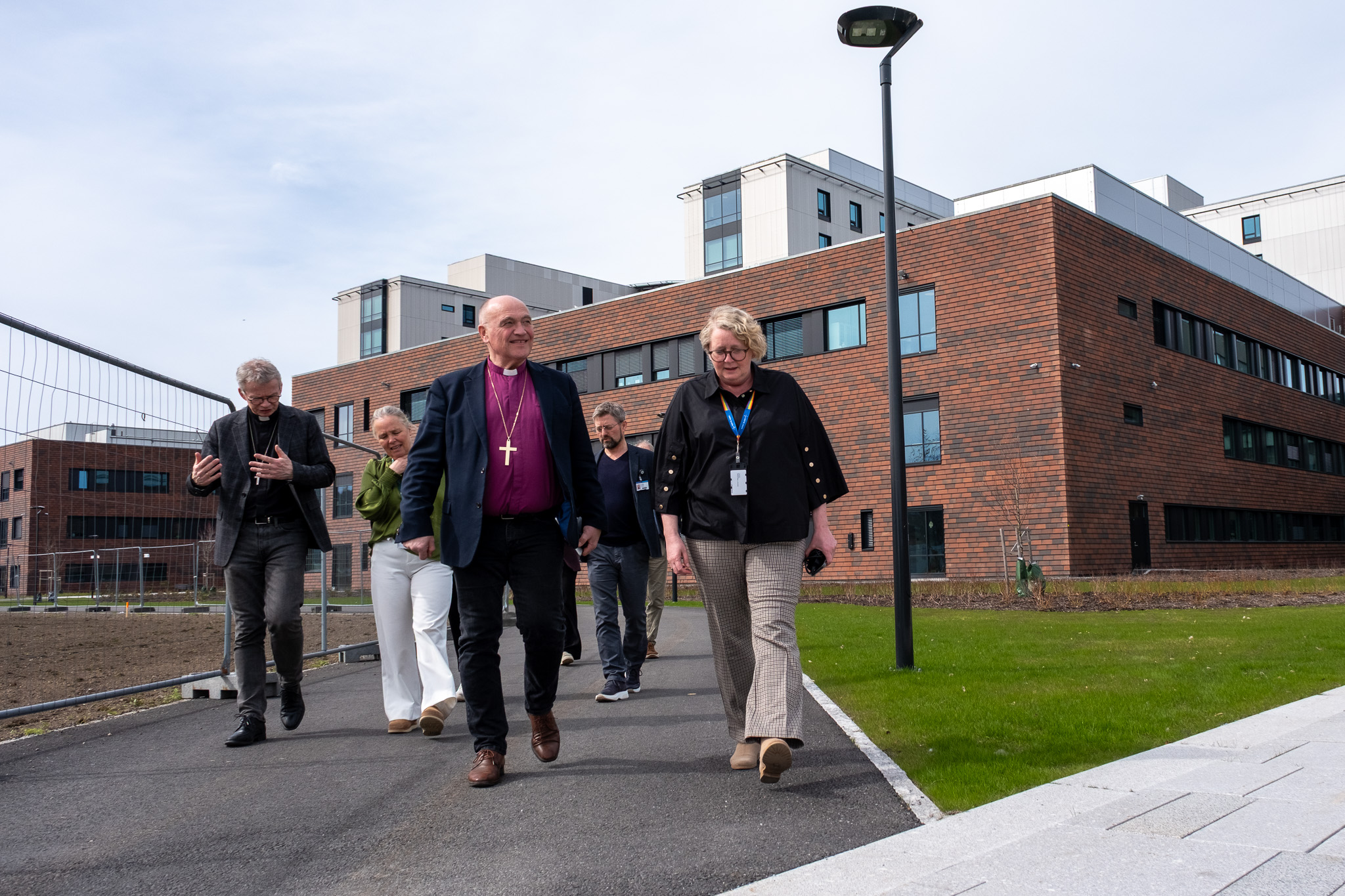 En gruppe mennesker som går utenfor en bygning