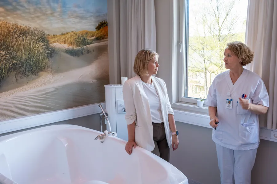 En kvinne og en mann som står ved et badekar