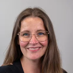 A woman with long hair and glasses