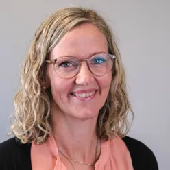 A person with glasses smiling