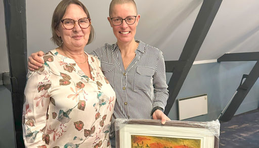 A man and woman holding a framed picture