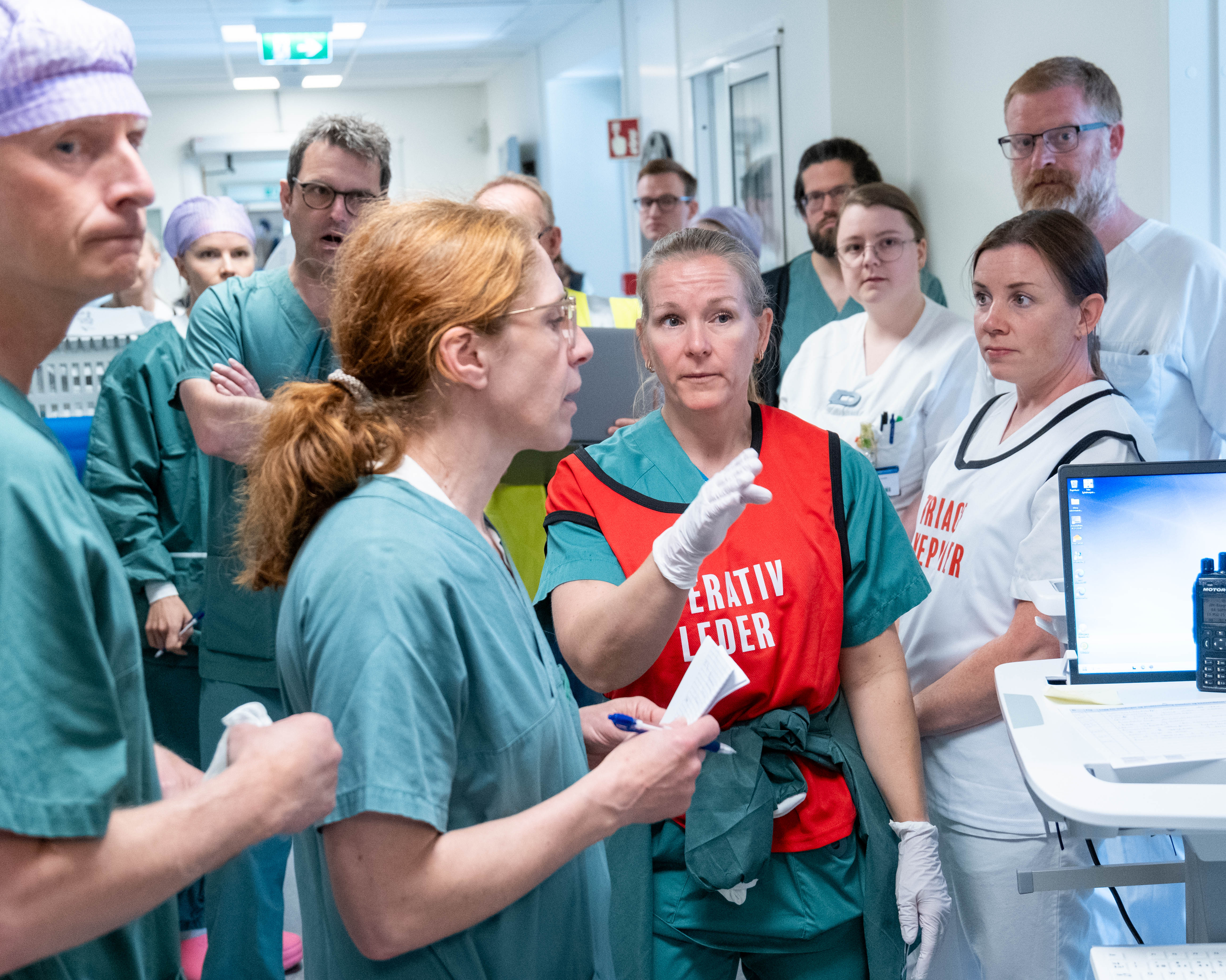 En gruppe mennesker som står rundt en mann som holder en mikrofon