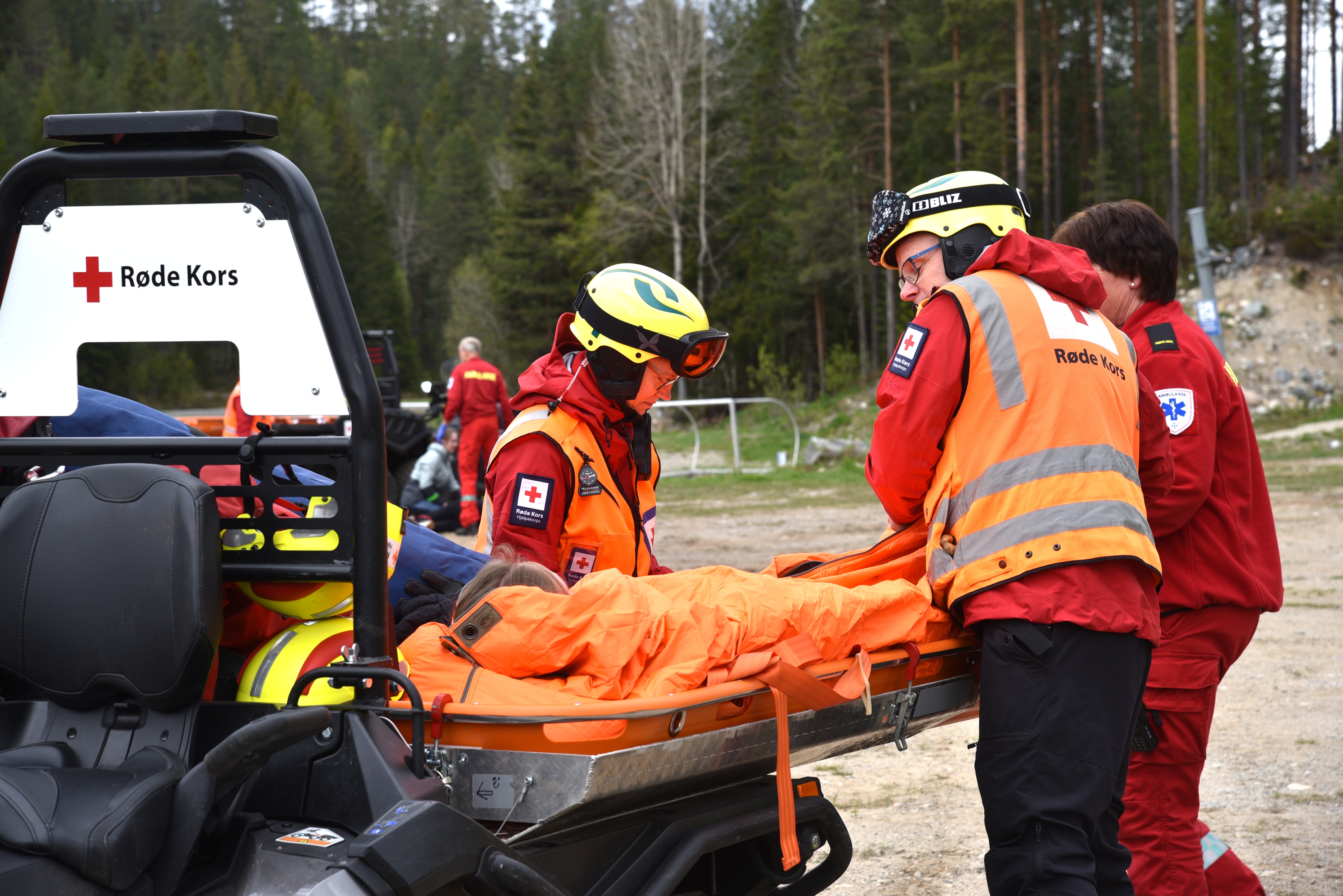 En gruppe mennesker i oransje jakker