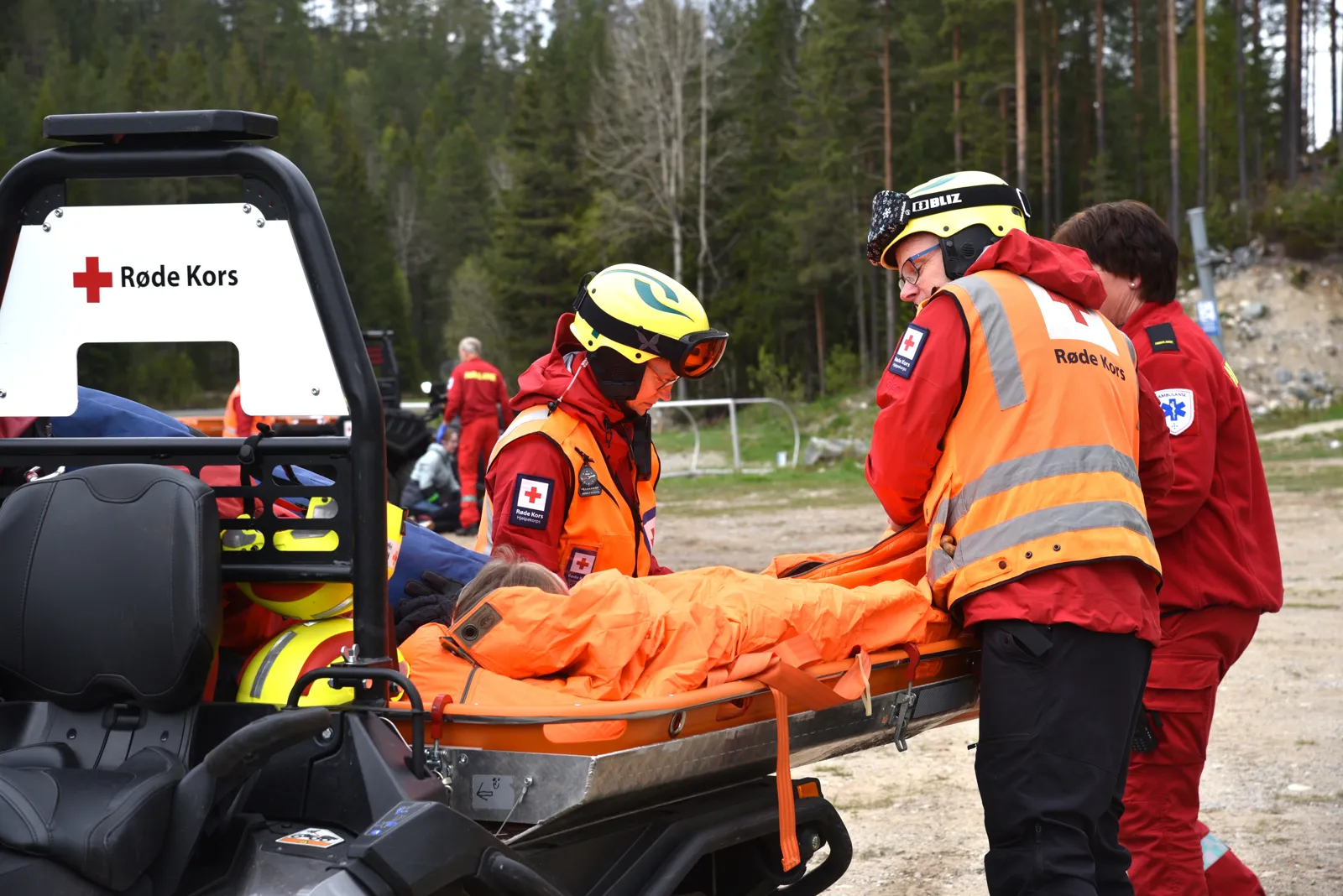En gruppe mennesker i oransje jakker