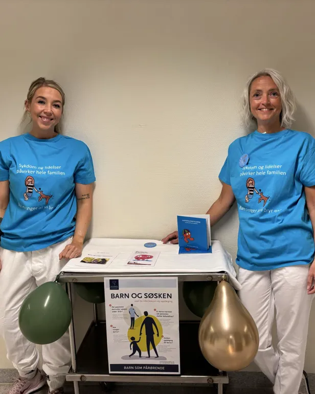 Et par kvinner som står ved siden av et bord med et trofé