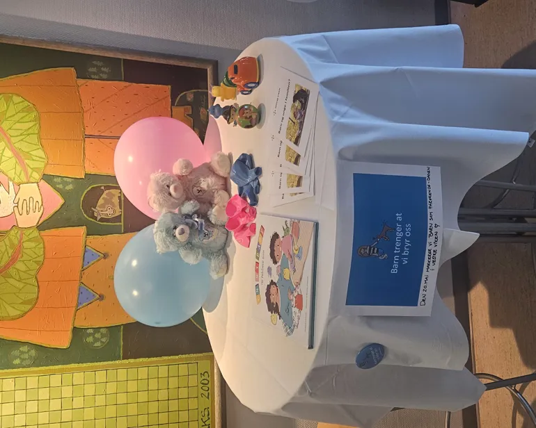 Et bord med en utstoppet bjørn og ballonger