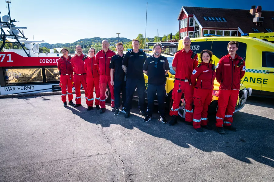 En gruppe mennesker i røde jumpsuits som poserer for et bilde