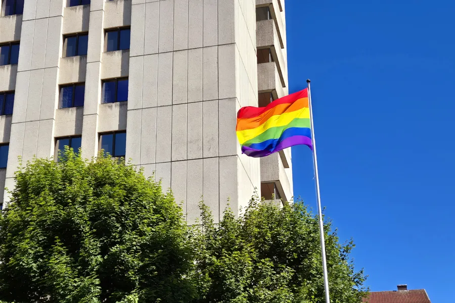 Et regnbueflagg som vaier foran en bygning