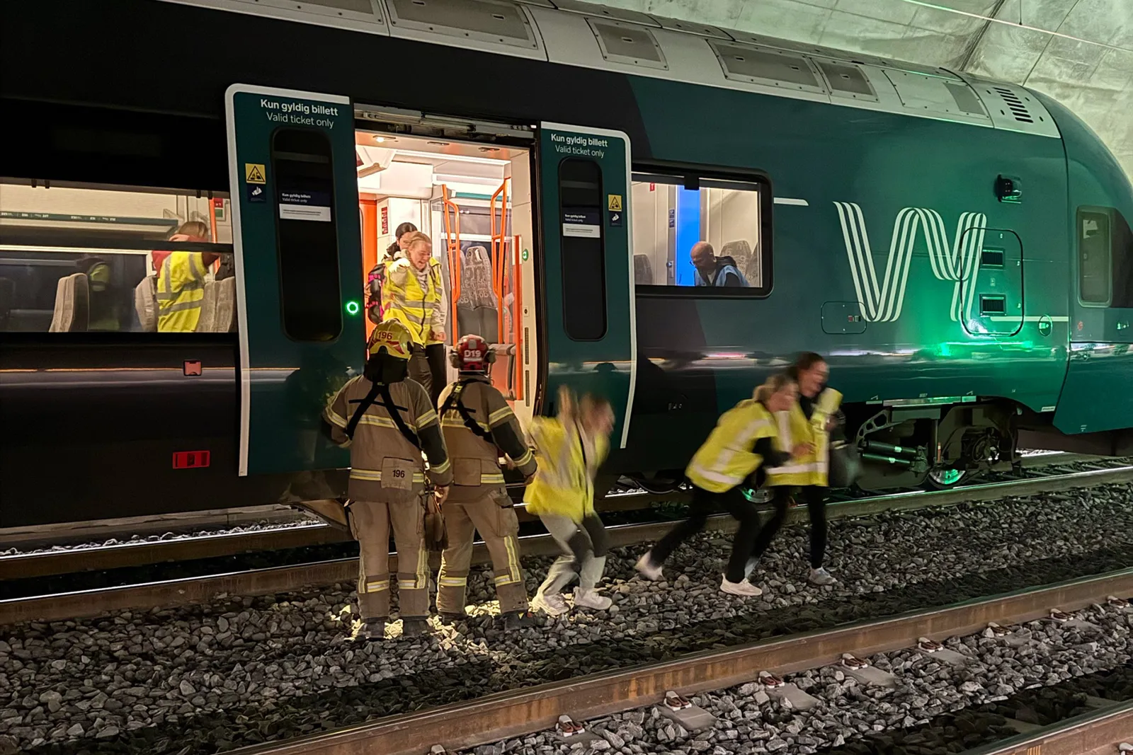 En gruppe mennesker som står ved siden av et tog