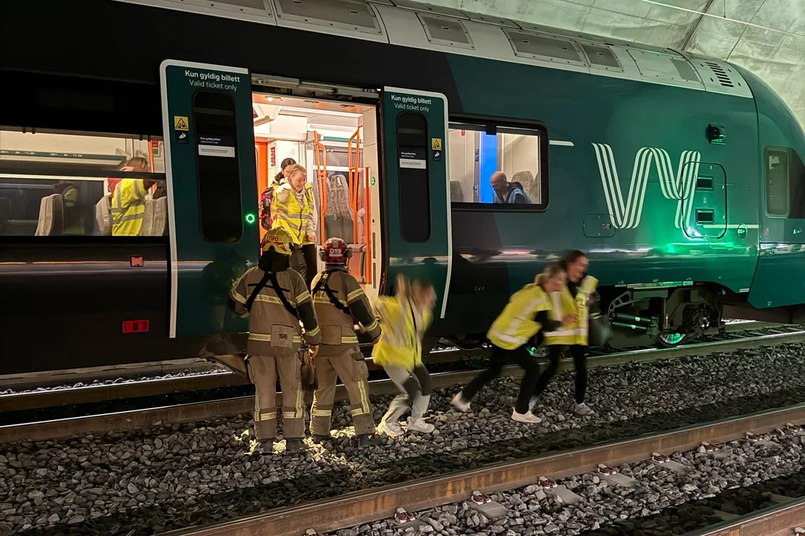 En gruppe mennesker som står ved siden av et tog