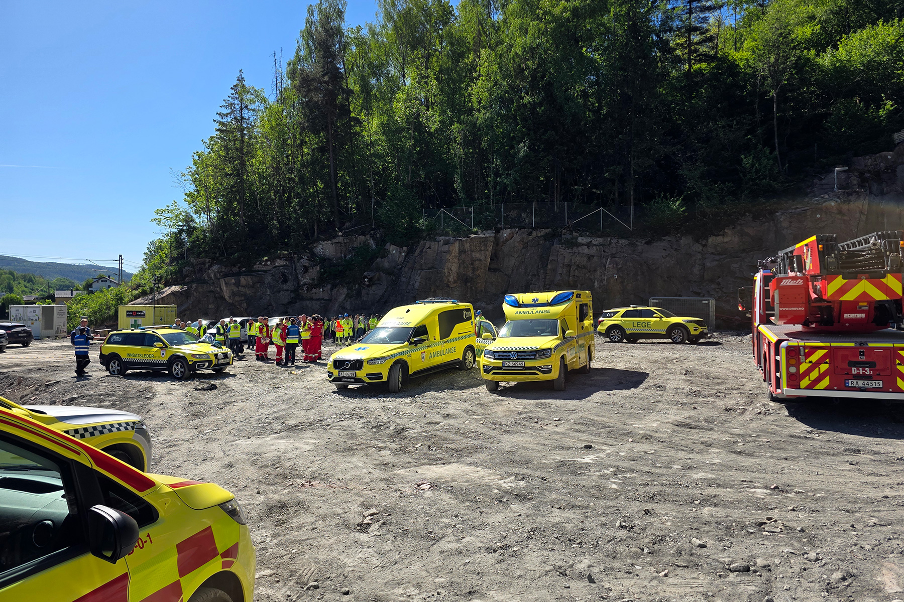 En gruppe biler parkert på en grusvei