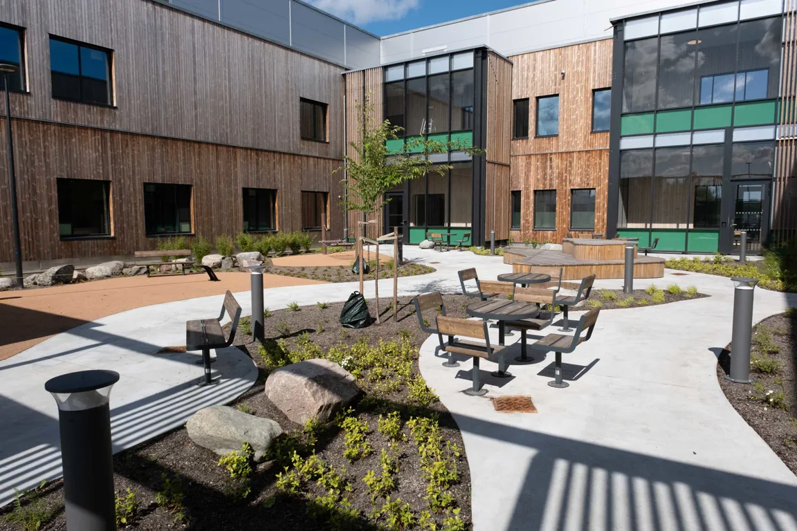 En gårdsplass med bord og stoler