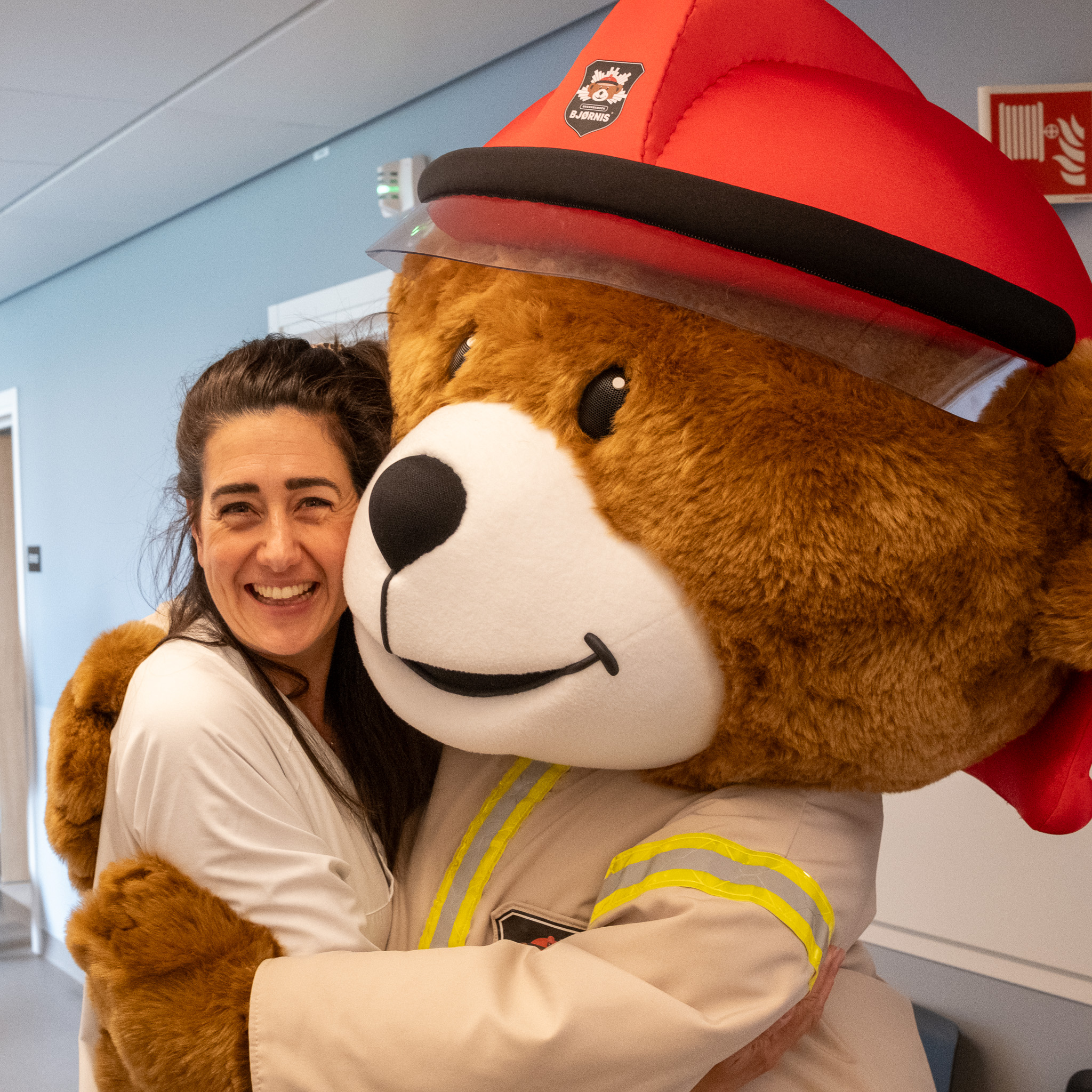 En person som står ved siden av en stor kosebamse