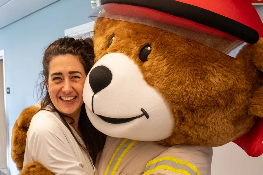 En person som står ved siden av en stor kosebamse