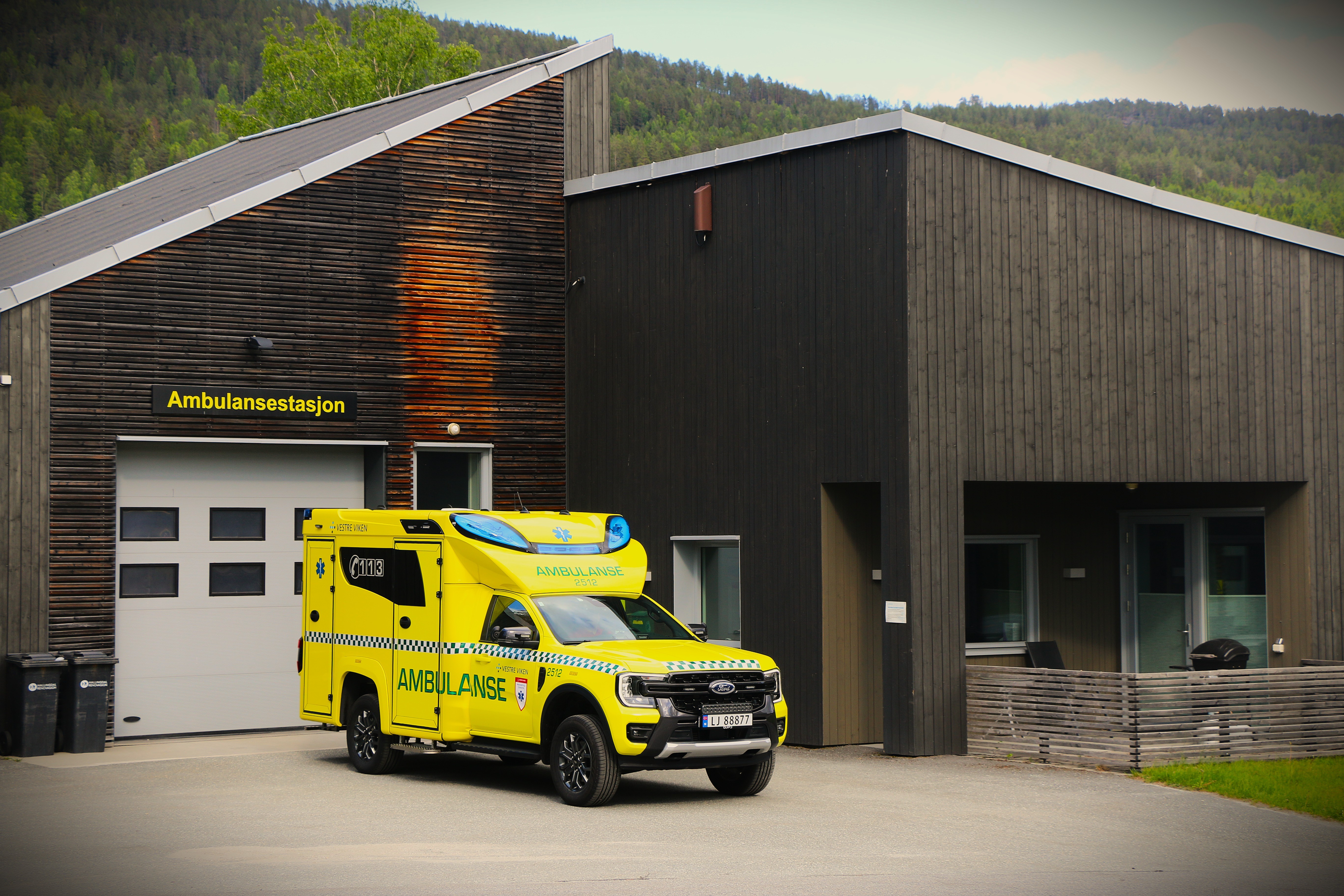 En gul lastebil parkert utenfor en bygning
