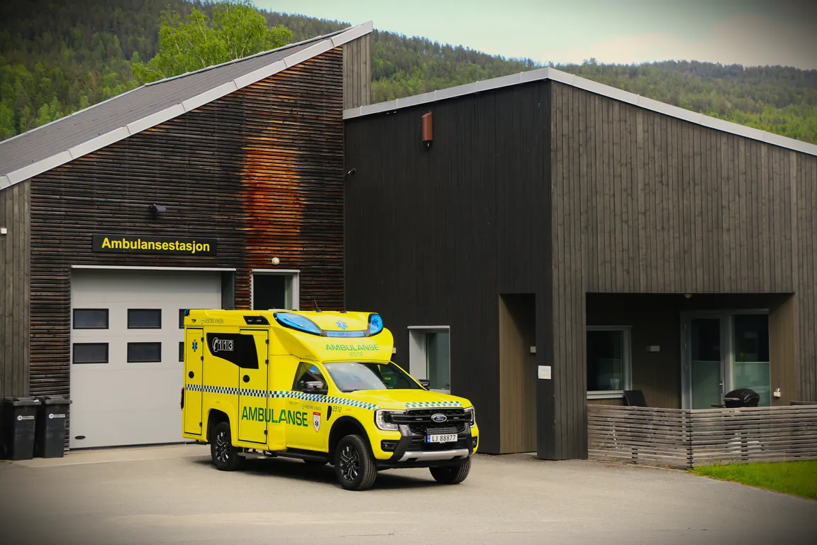 En gul lastebil parkert utenfor en bygning