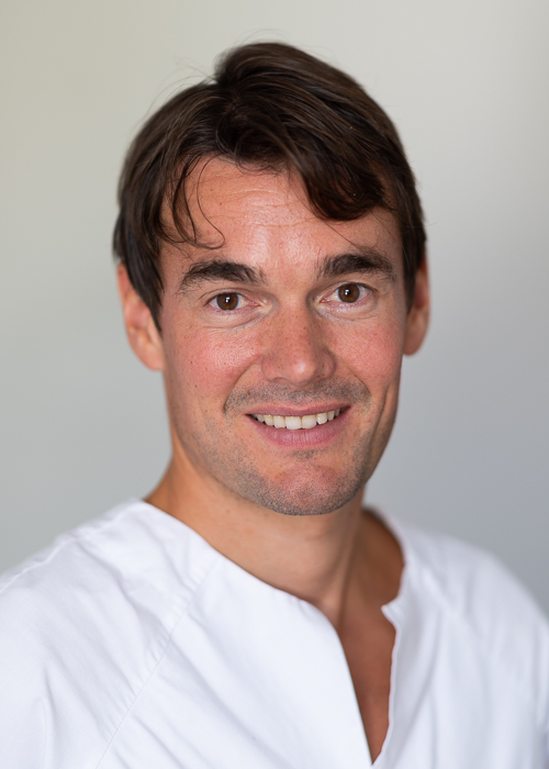 En mann som smiler til kameraet