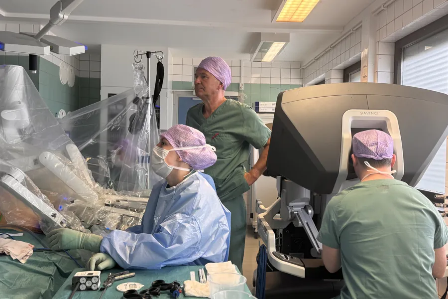 En gruppe mennesker i kirurgiske uniformer og masker i et rom