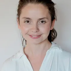 En kvinne som smiler til kameraet